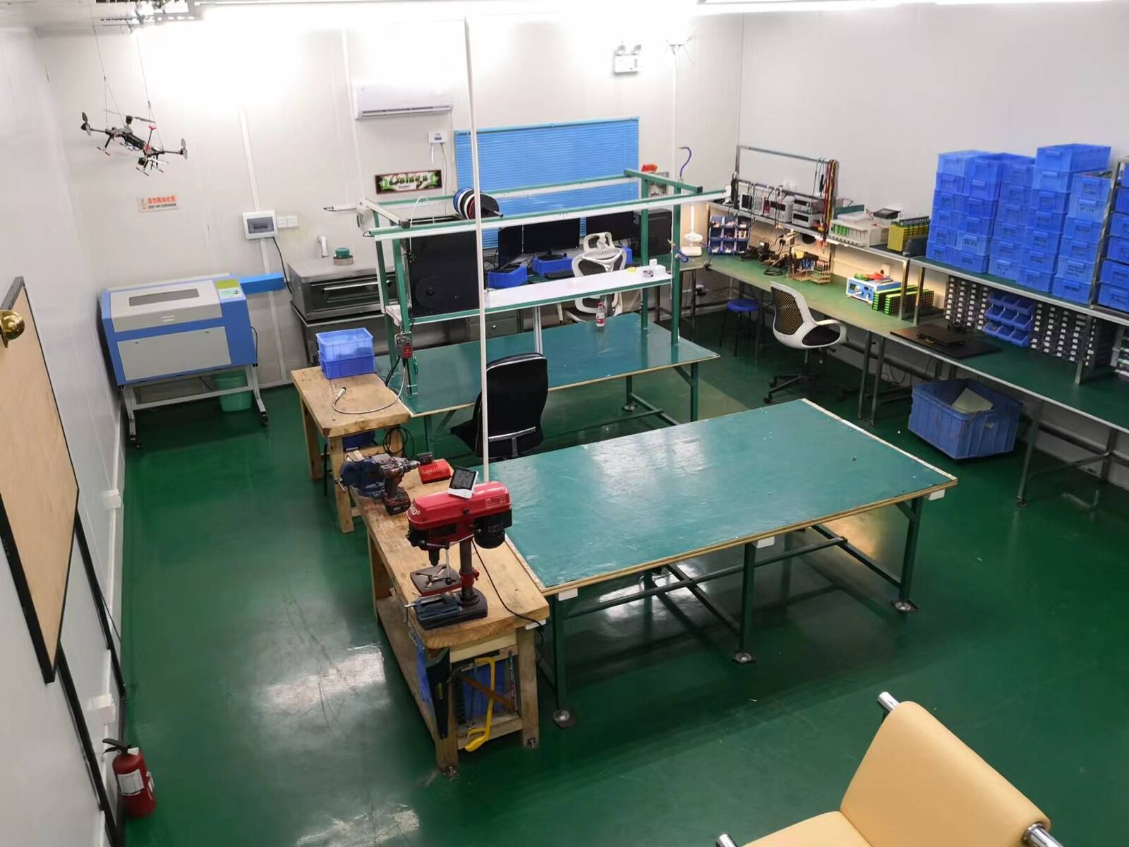 A small test and assembly lab with benches, a drone and a laser cutter.